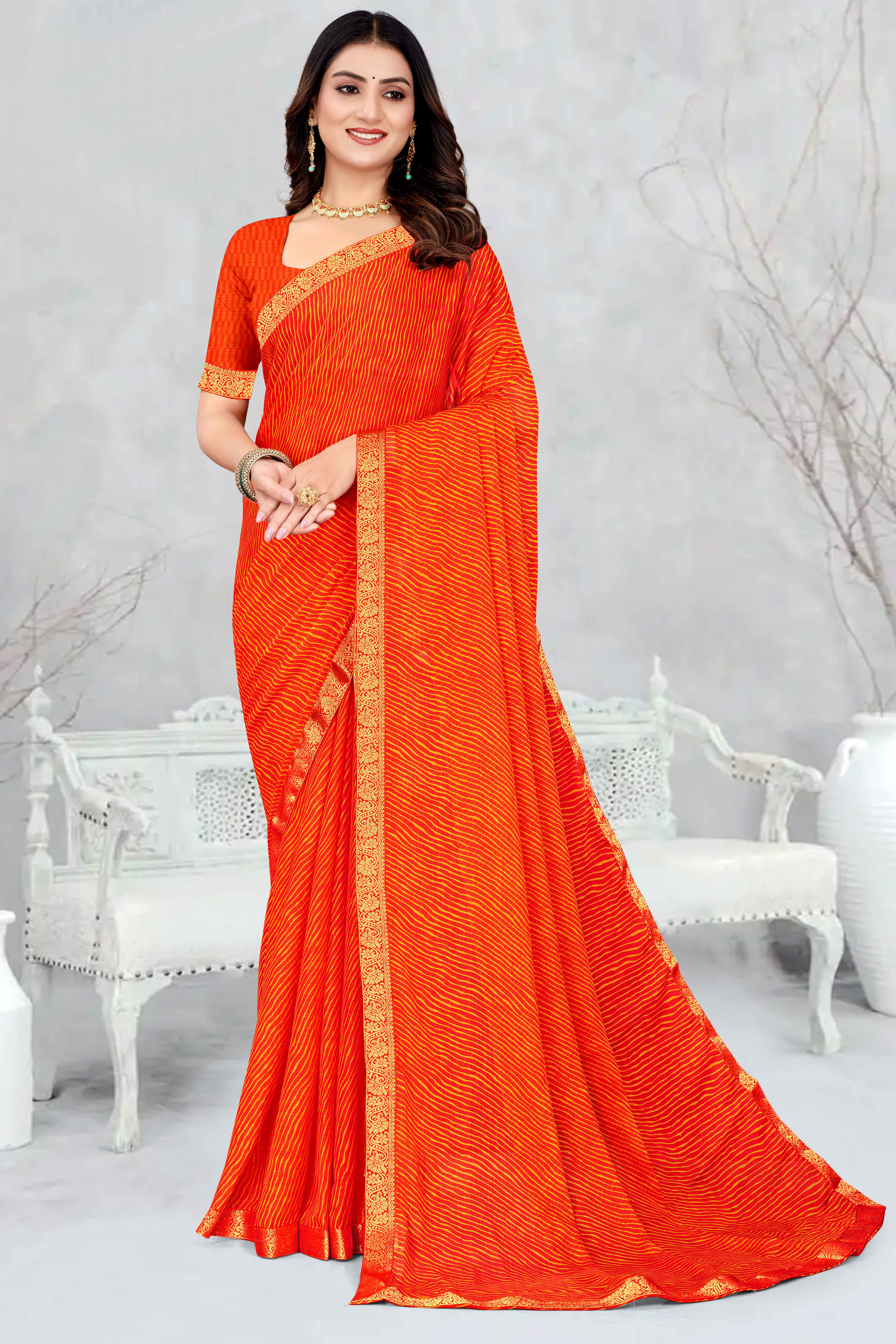 Orange Leheriya Printed Chiffon Saree Accented With A Graceful Floral Weaving Lace Border