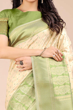 Cream Banarasi Silk Saree Featuring Lustrous Light Green Floral Zari Weaving and a Rich Contrast Border