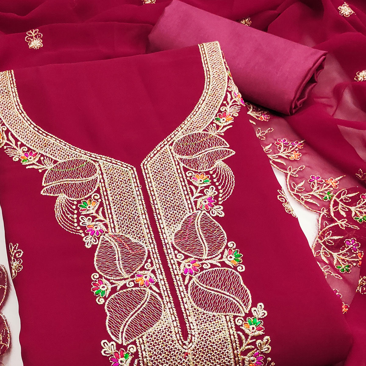 Rani Pink Georgette Dress Material Adorned With Floral Embroidery & Elegant Lace Border