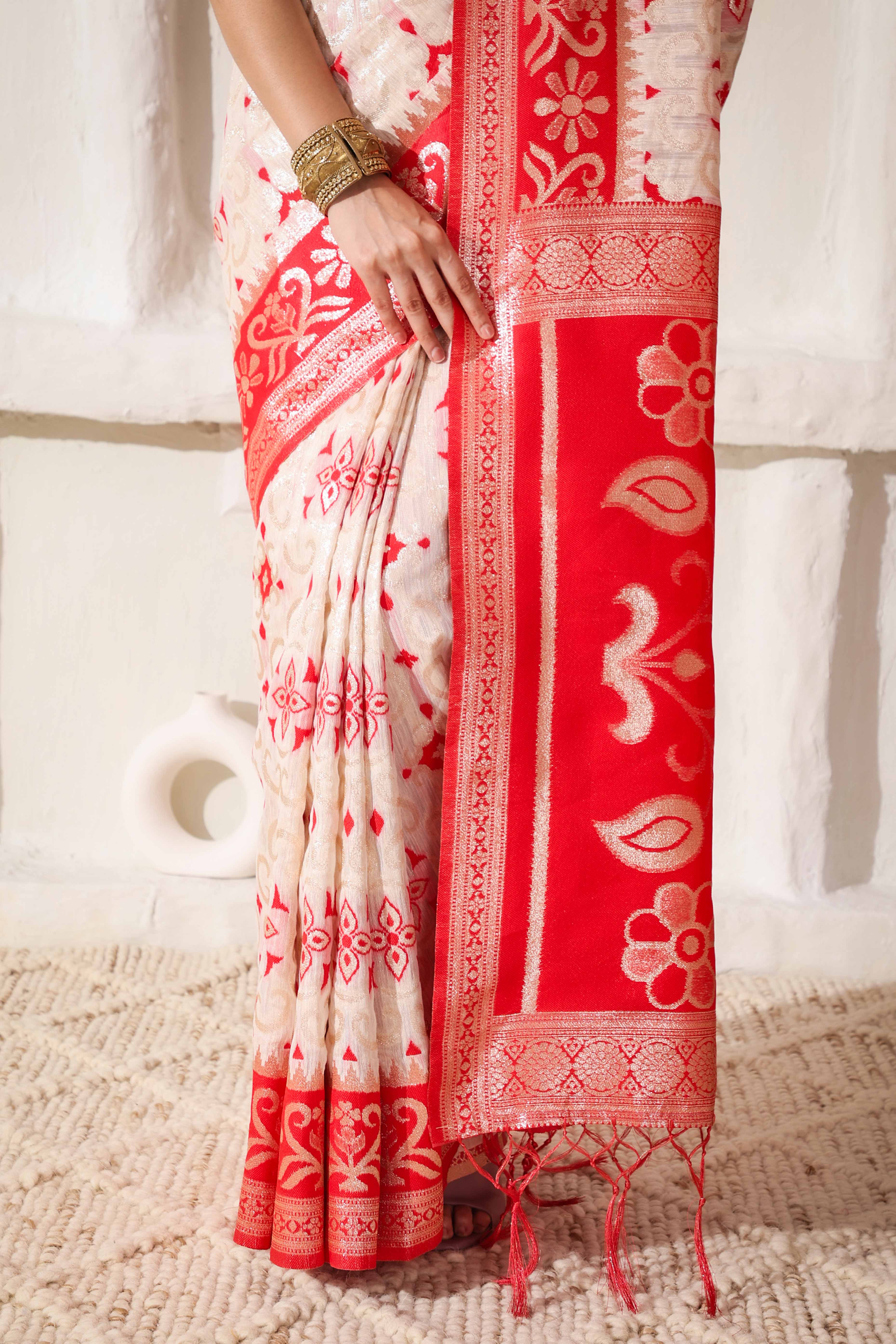 White & Red Linen Cotton Saree Adorned With Intricate Zari Weaving And Tassel Pallu