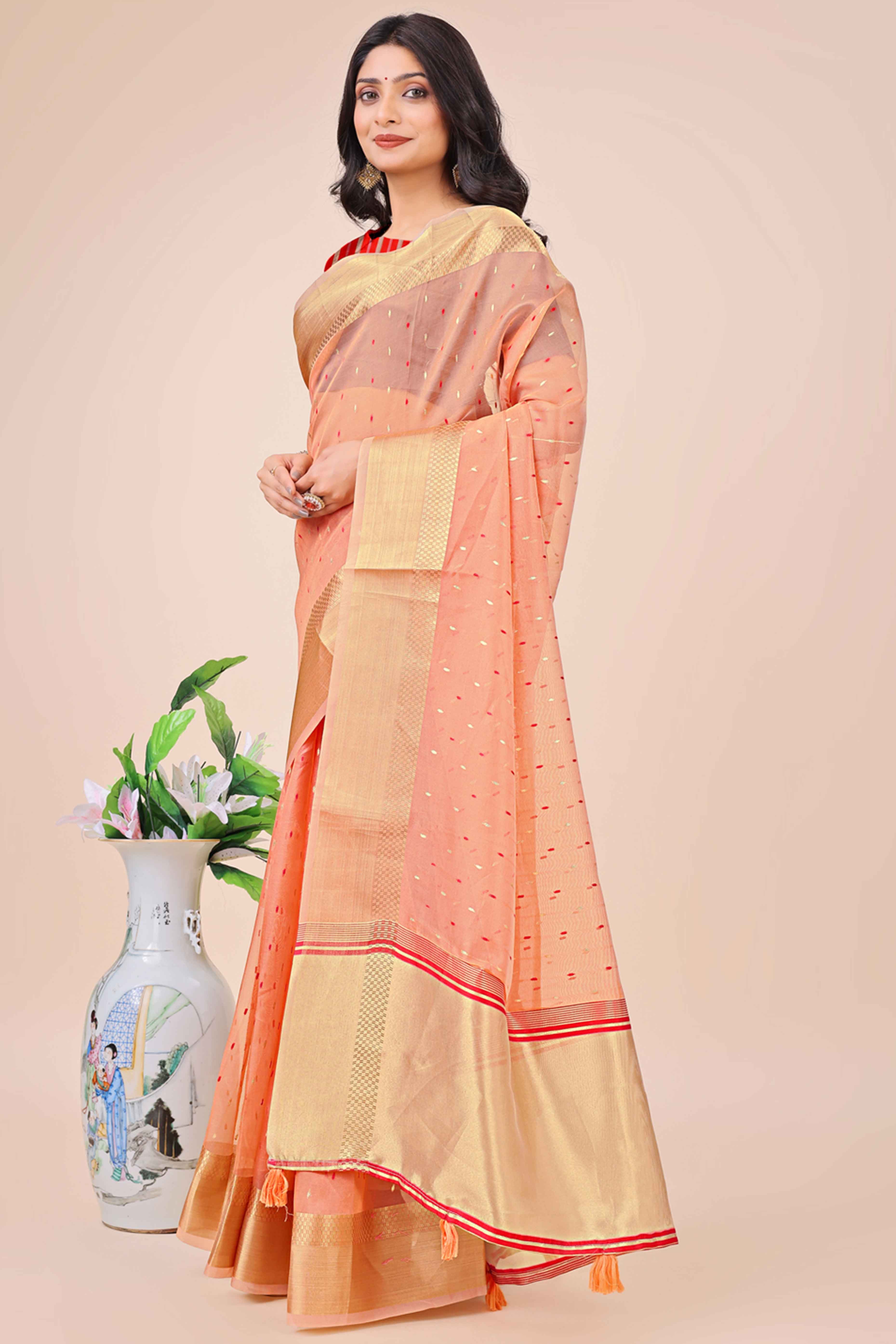 Peach Organza Saree Adorned With Fine Zari Weaving & Stylish Tassel Edging