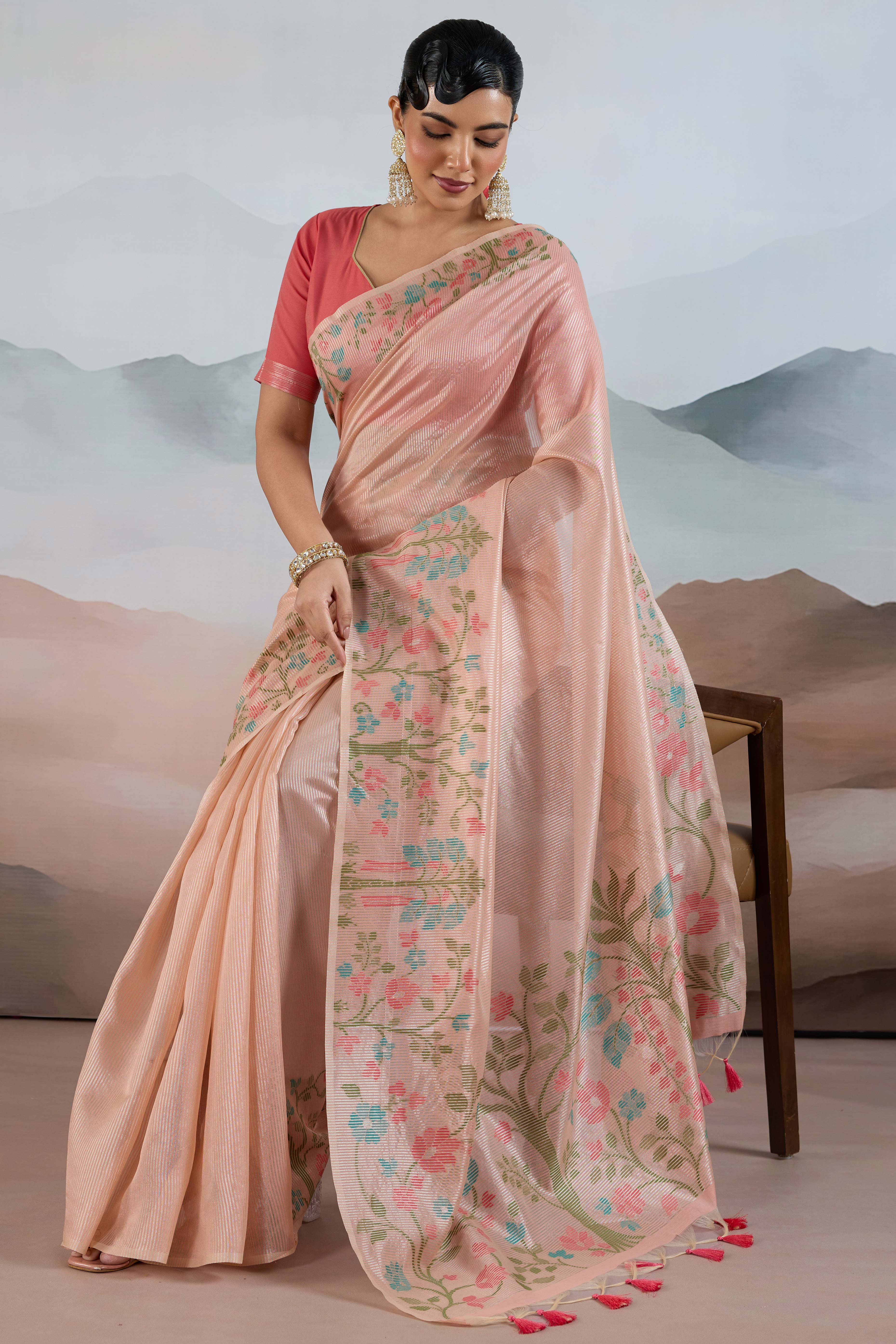 Peach Tissue Silk Saree Showcasing Floral & Striped Weaving With Tassel Adornment