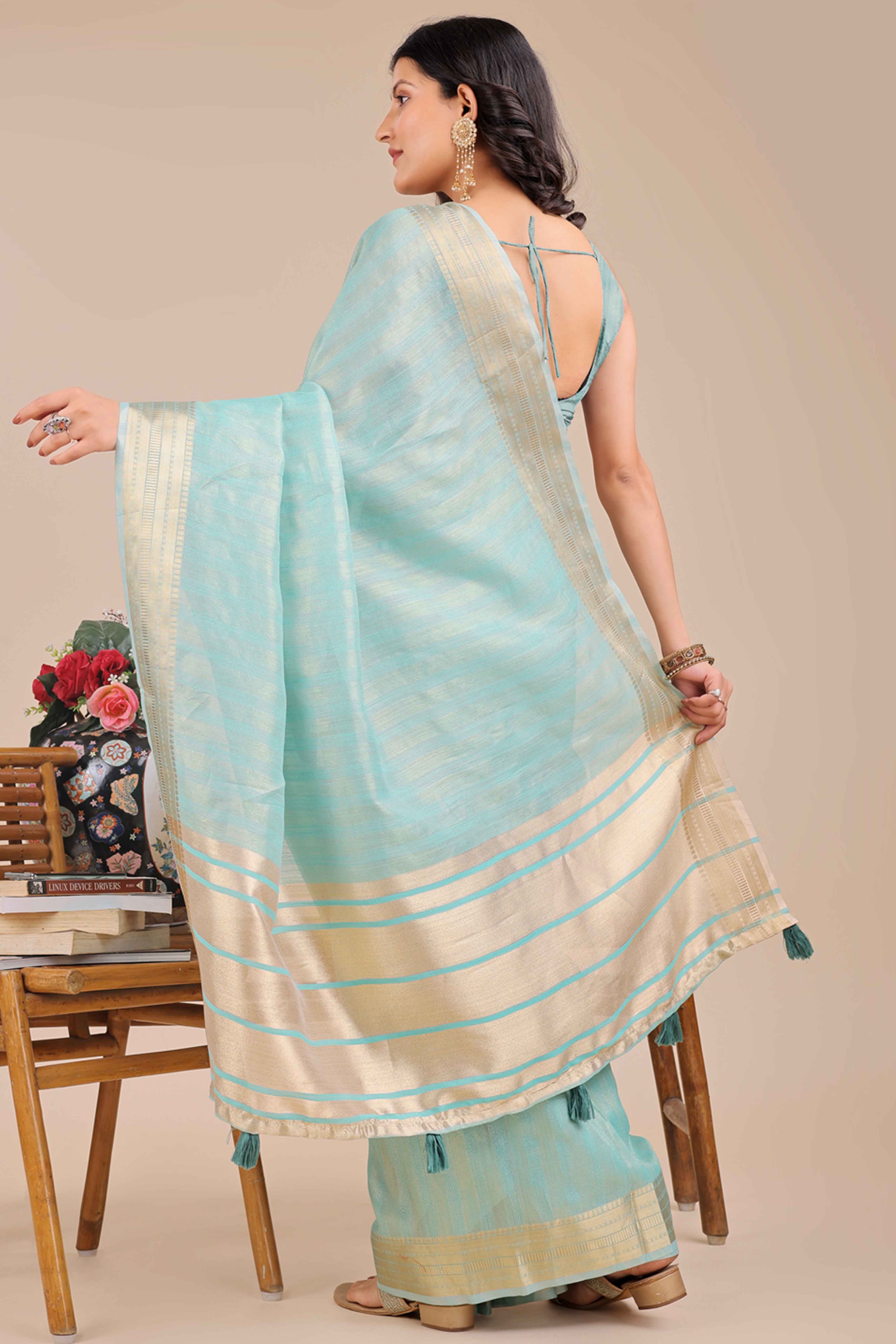 Light Turquoise Organza Saree With Intricate Weave & Elegant Tassel Accents