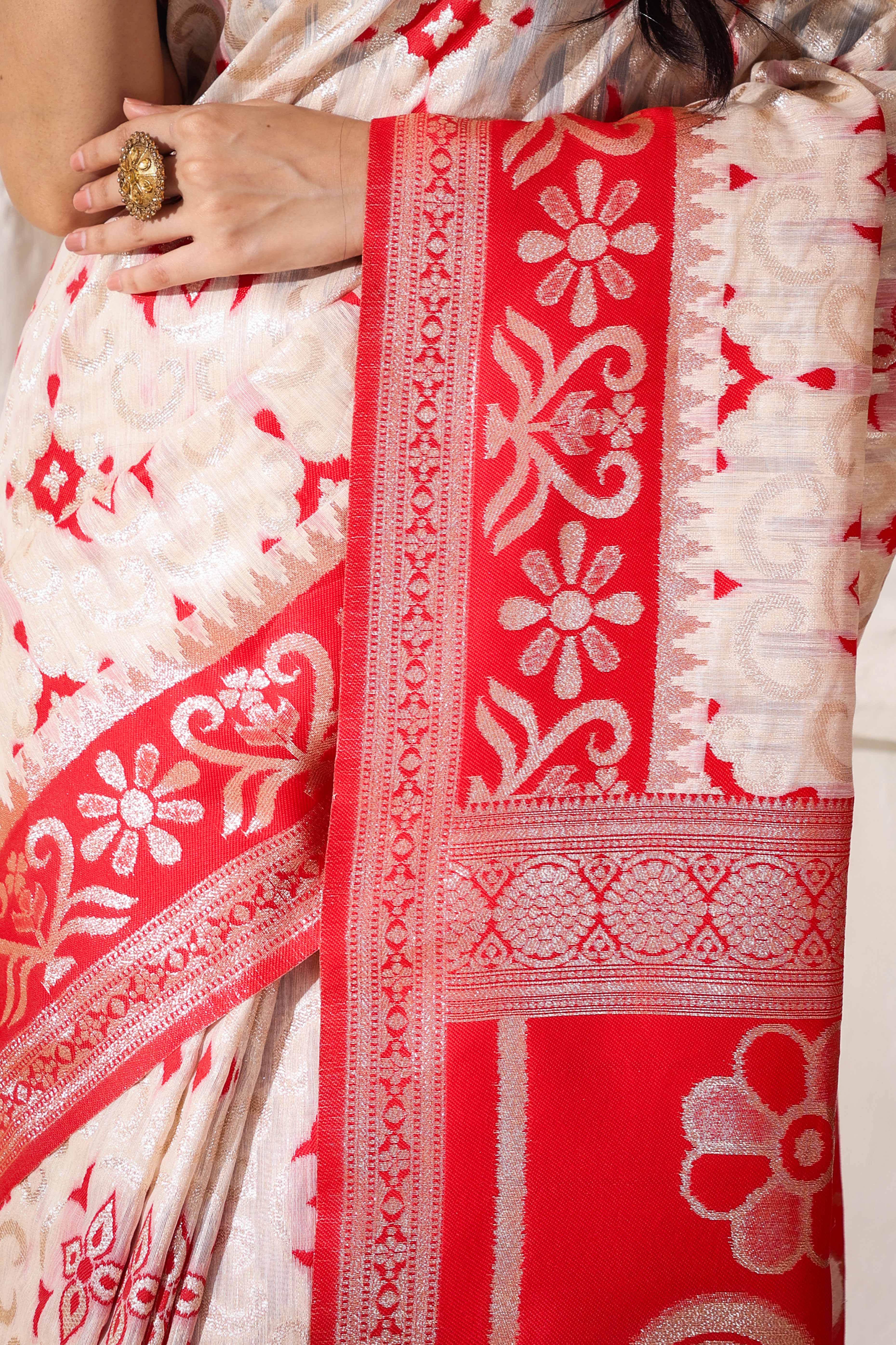 White & Red Linen Cotton Saree Adorned With Intricate Zari Weaving And Tassel Pallu