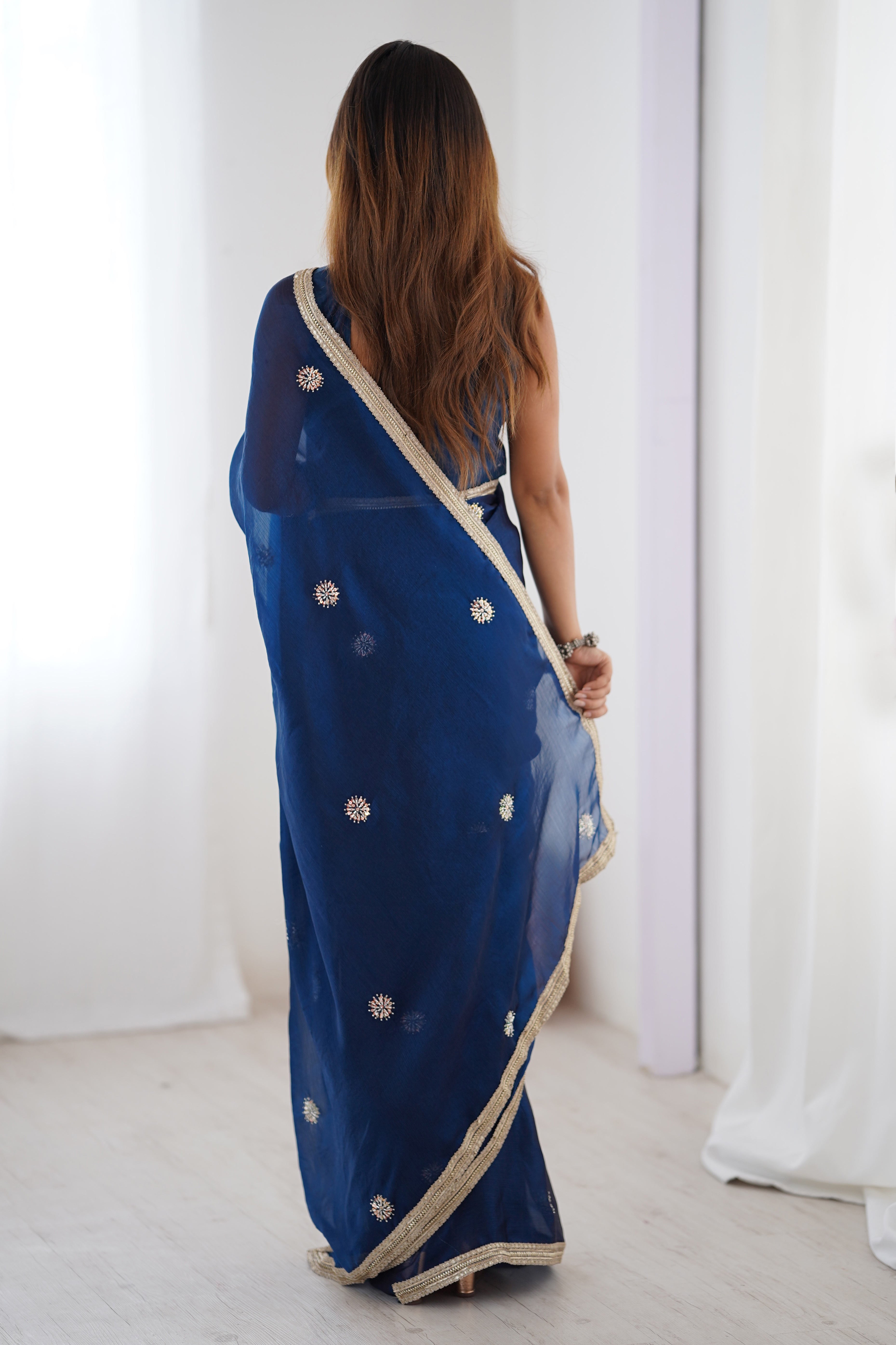 Elegant Blue Organza Saree with Delicate Floral Embellishments and Lace Border