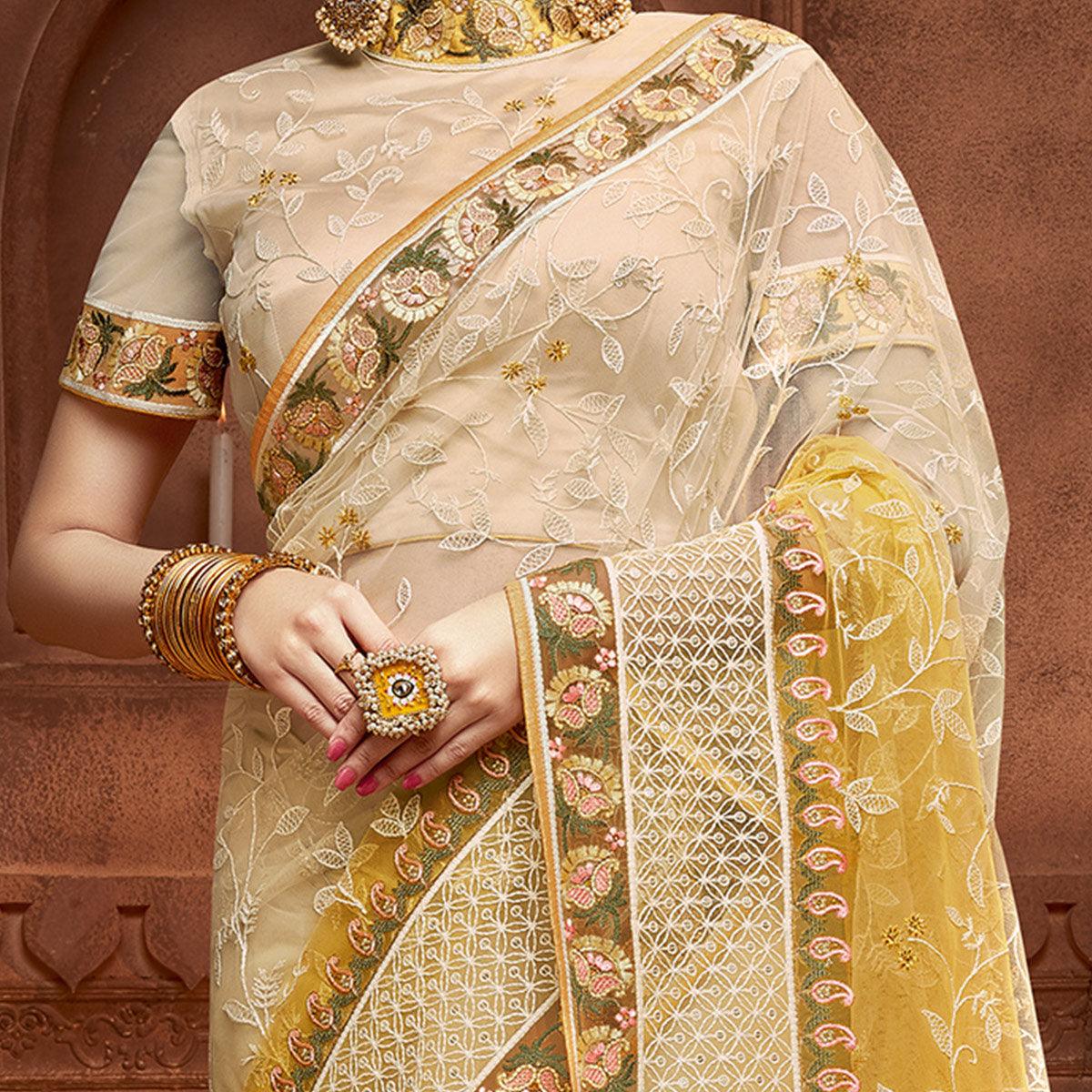 Capricious Beige & Mustard Coloured Partywear Embroidered Soft Net Saree - Peachmode